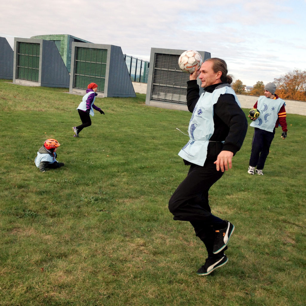 a man in a custom uniform throwing a soccer ball in the field.